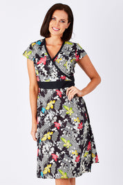 Model Perrie wearing size S of the Leela Print Cotton Wrap Dress in colour Nikko (Black), from the front, cropped image