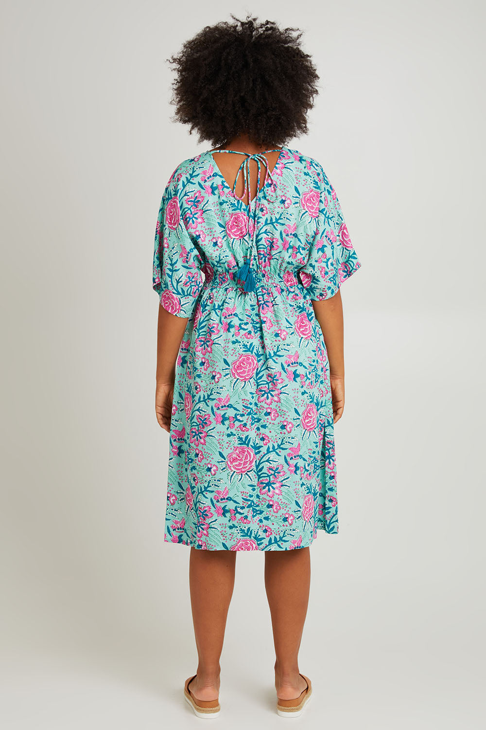 Model Olivia wearing the Evie Dress in colour Crete (Blue), from the back