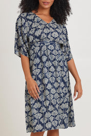 Model Ziara wearing the Evie Dress in colour Yamba, from the front, cropped image