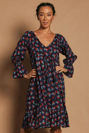Model Katie wearing the Valeria Dress in colour Soho (Blue), from the front, cropped image