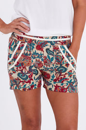 Model Alex wearing the Pip Shorts in colour Remyprint (Red), from the front, cropped image