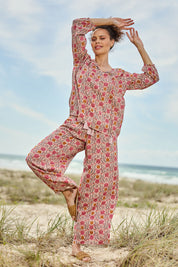 Model Lala wearing the Nat Pant in colour Rhodes (Pink), from the front, showing the whole outfit