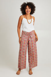 Model Olivia wearing the Nat Pant in colour Rhodes (Pink), from the front, showing the whole outfit