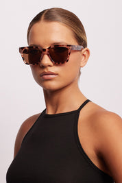 A model wearing the Anvil Square Sunglasses in colour Blossom, from the front, showing the whole outfit