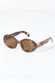 A model wearing size OneSize of the Beautiful Stranger Eco Sunglasses in colour Honeyturt, from the front, showing the whole outfit