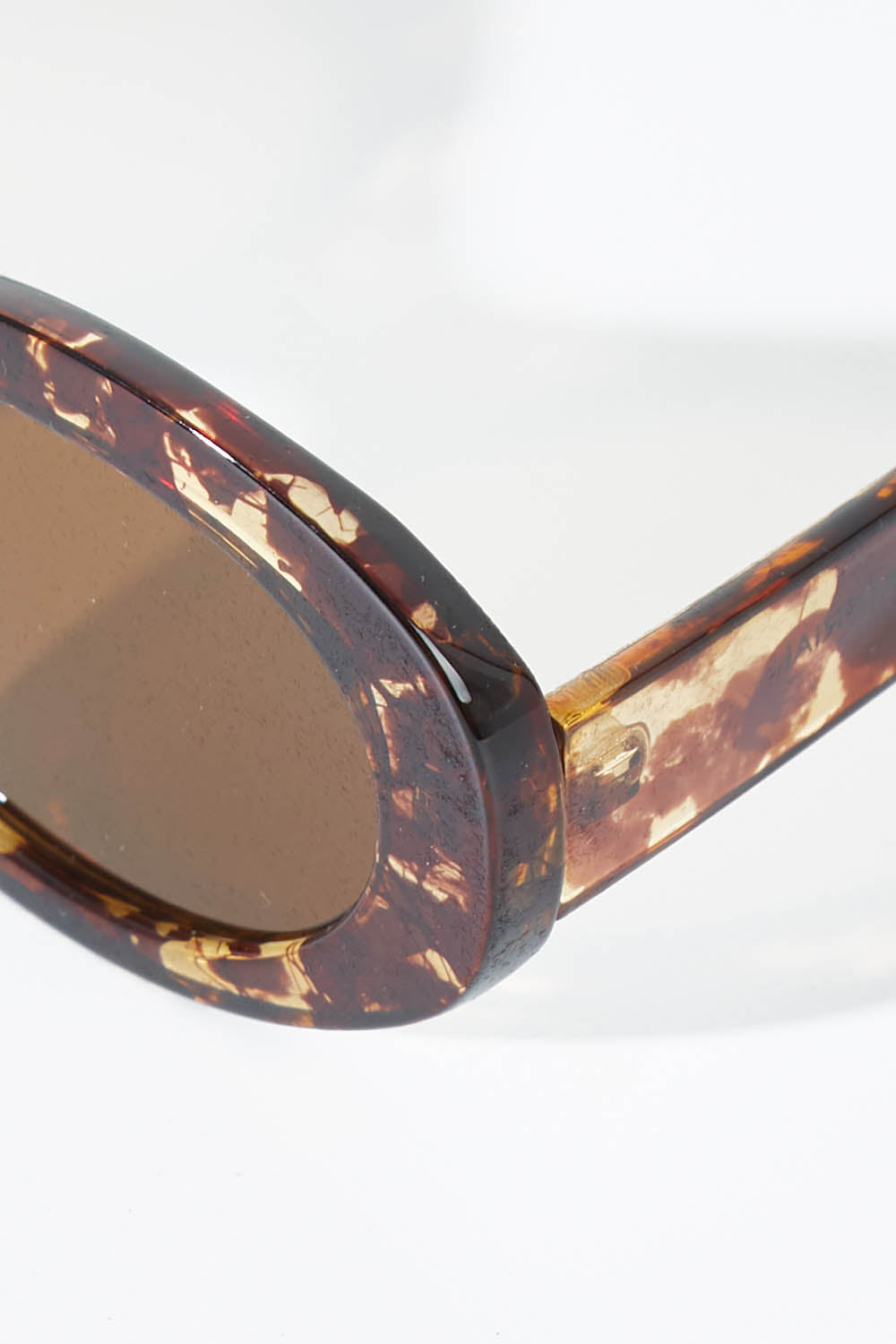 A model wearing size OneSize of the Beautiful Stranger Eco Sunglasses in colour Honeyturt, from the front, showing the whole outfit