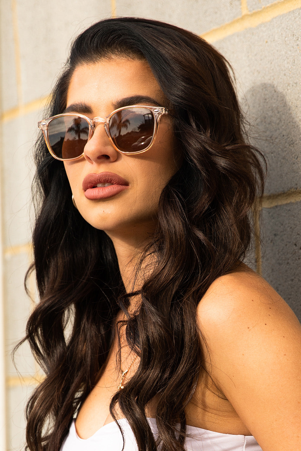 A model wearing The Chelsea Square Sunglasses in colour Prosecco, from the front, cropped image