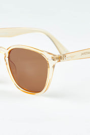 A model wearing The Chelsea Square Sunglasses in colour Prosecco, from the front, showing the whole outfit
