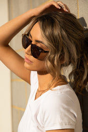 A model wearing The Chelsea Square Sunglasses in colour Tortoise, from the front, cropped image