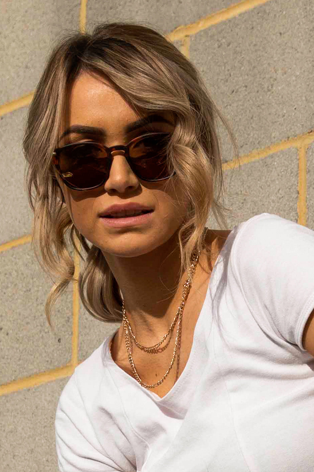 A model wearing The Chelsea Square Sunglasses in colour Tortoise, from the front, cropped image
