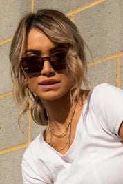 A model wearing The Chelsea Square Sunglasses in colour Tortoise, from the front, cropped image