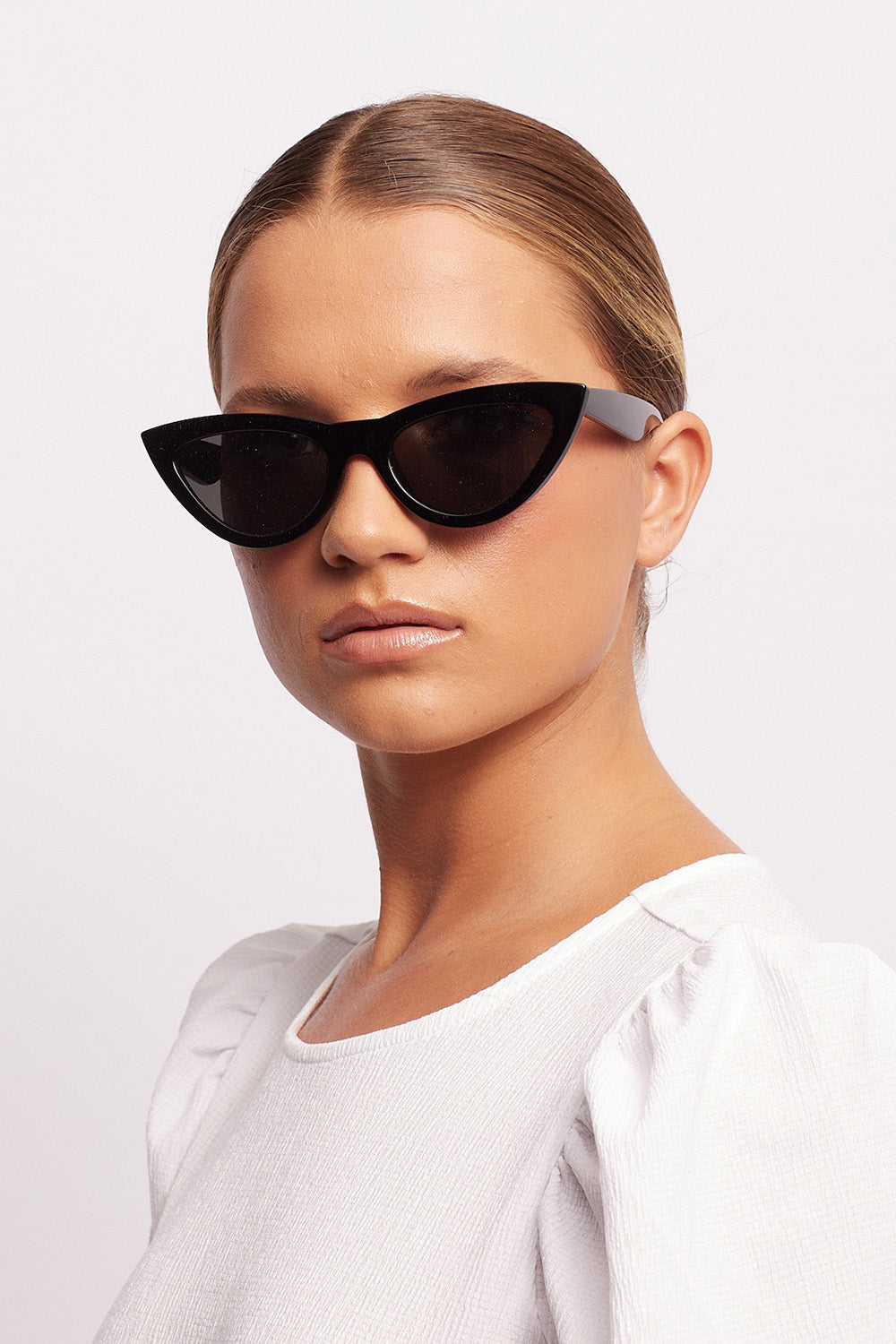 A model wearing the Kiss Kiss Sunglasses in colour Black (Black), from the front, showing the whole outfit