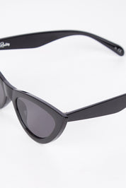 A model wearing the Kiss Kiss Sunglasses in colour Black (Black), from the front, showing the whole outfit