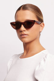 A model wearing the Kiss Kiss Sunglasses in colour Mocca, from the front, showing the whole outfit
