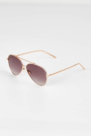 A model wearing size OneSize of the Mr Chips Sunglasses in colour RoseGold (Metallics), from the front, showing the whole outfit