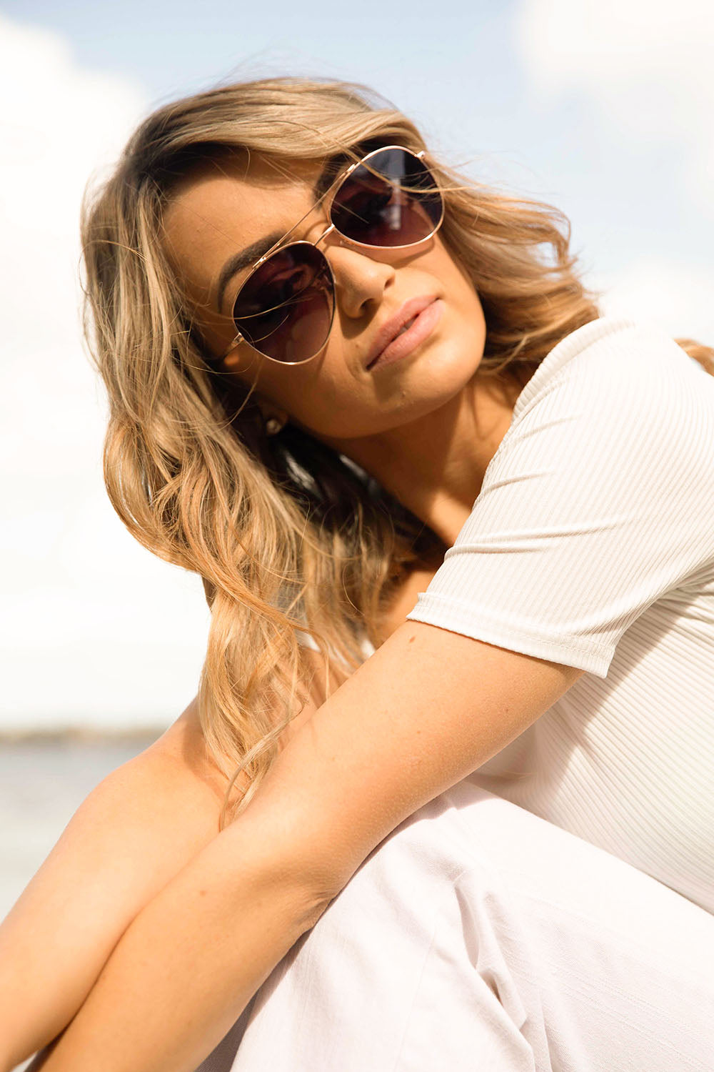 A model wearing the Mr Chips Sunglasses in colour RoseGold (Metallics), from the front, showing the whole outfit