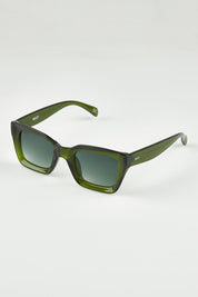 A model wearing size OneSize of the Onassis Polarized Square Sunglasses in colour Mossgreen (Green), from the front, showing the whole outfit