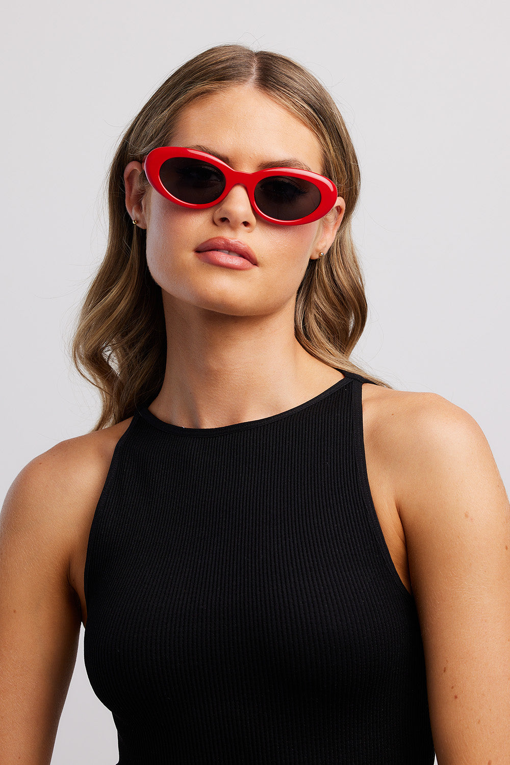 A model wearing the Siren Cats Eye Sunglasses in colour Red (Red), from the front, showing the whole outfit