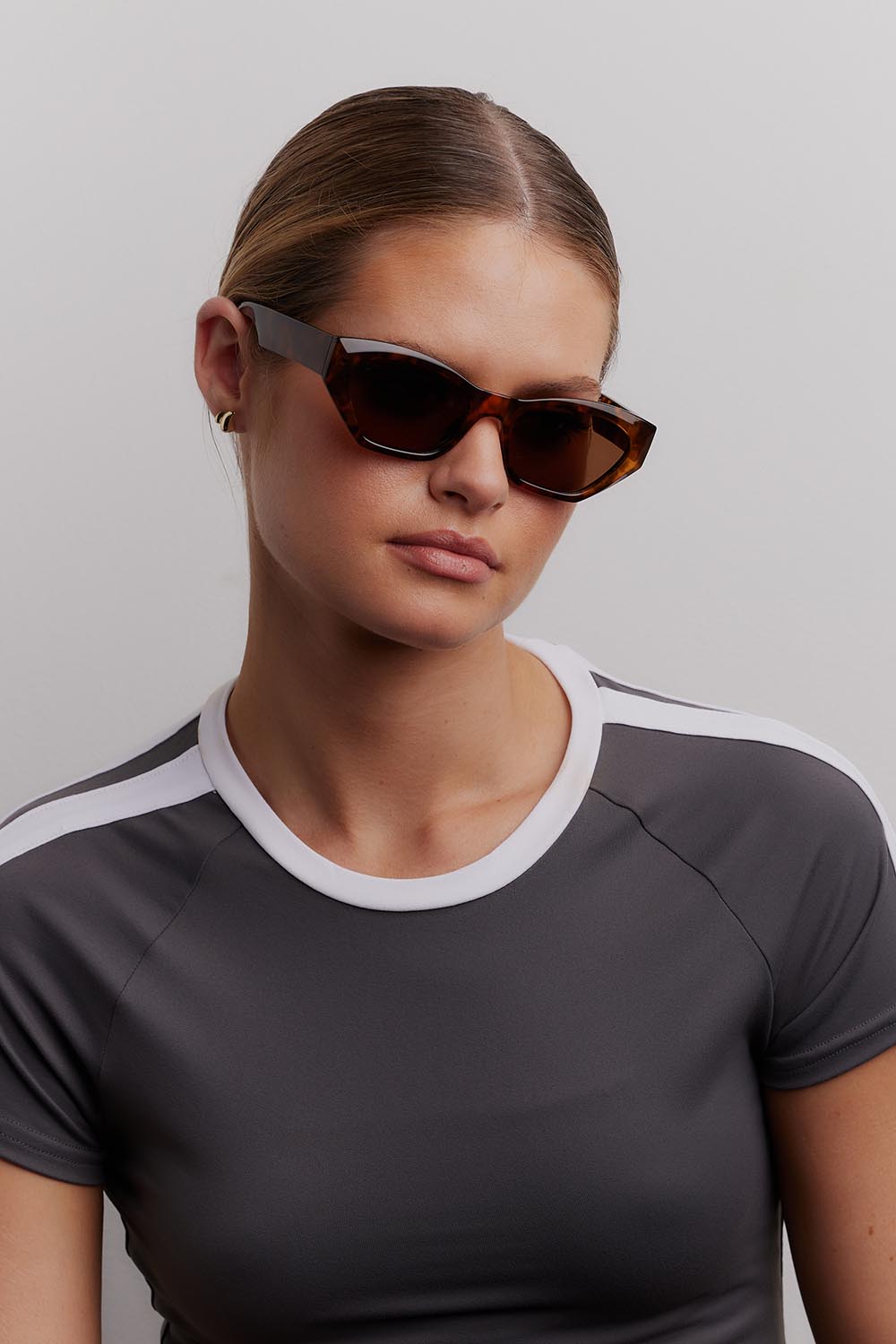 A model wearing the Wall Of Sound Sunglasses in colour Turtle, from the front, cropped image
