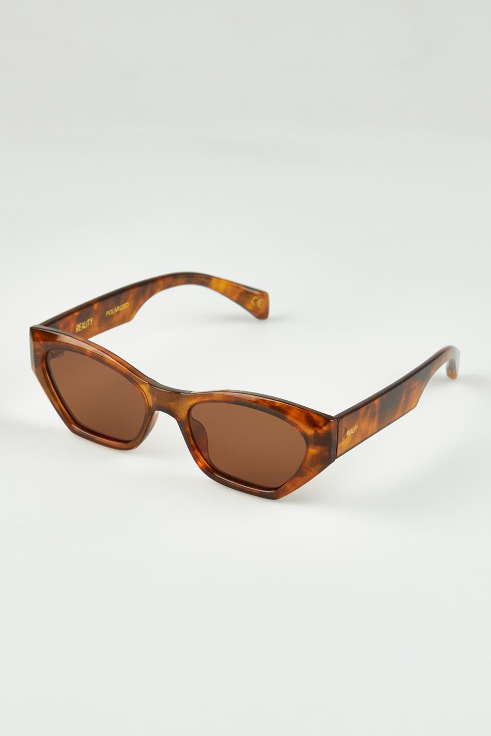 A model wearing the Wall Of Sound Sunglasses in colour Turtle, from the front, showing the whole outfit