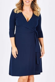 Model Jess wearing size L of the Essential Little Navy Dress in colour Navy (Blue), from the front, cropped image