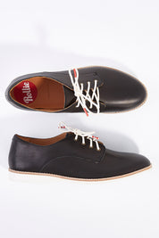 A model wearing size 38 of the Classic Derby Flat in colour Black (Black), from the front, showing the whole outfit