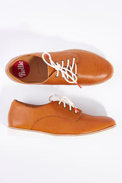 A model wearing size 38 of the Classic Derby Flat in colour Cognac, from the front, showing the whole outfit