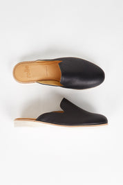 A model wearing size 37 of the Tumble Leather Derby Mule in colour Black (Black), from the front, showing the whole outfit