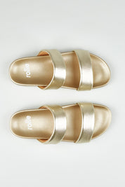 A model wearing size 37 of the Tide Leather Double Strap Slide in colour Softgold (Metallics), from the front, showing the whole outfit