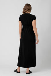 A model wearing the Misha Nursing Dress in colour Black (Black), from the back