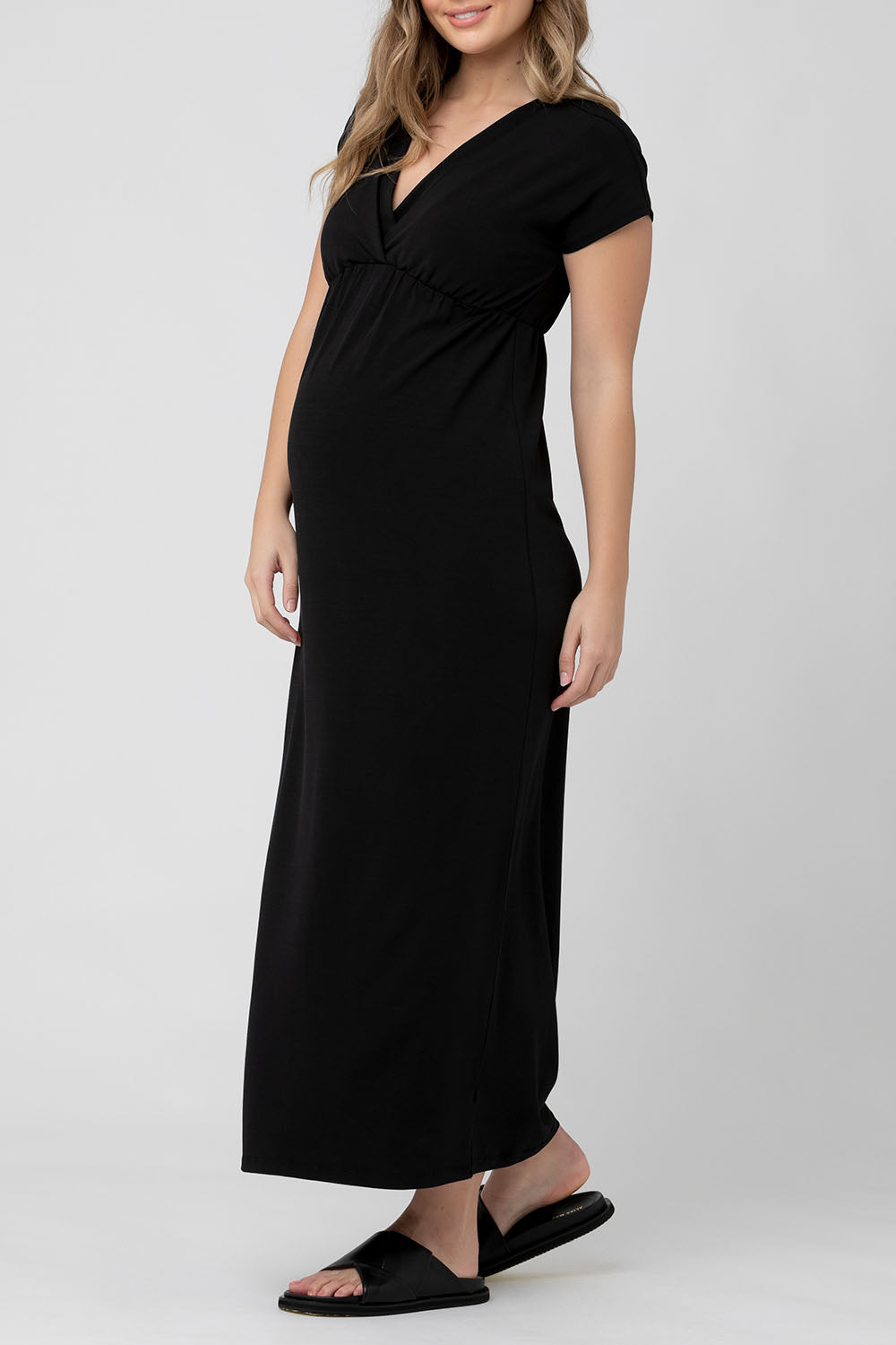 A model wearing the Misha Nursing Dress in colour Black (Black), from the front, cropped image