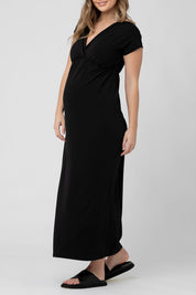 A model wearing the Misha Nursing Dress in colour Black (Black), from the front, cropped image