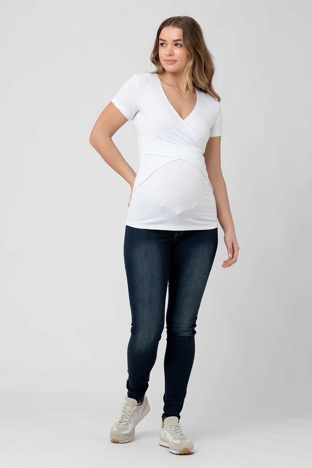 A model wearing the Embrace Tee in colour White (White), from the front, showing the whole outfit