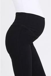 A model wearing the Suzie Maternity Super Straight Pant in colour Black (Black), from the front, cropped image