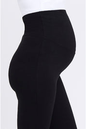 A model wearing the Over Tummy Maternity Legging in colour Black (Black), from the front, cropped image