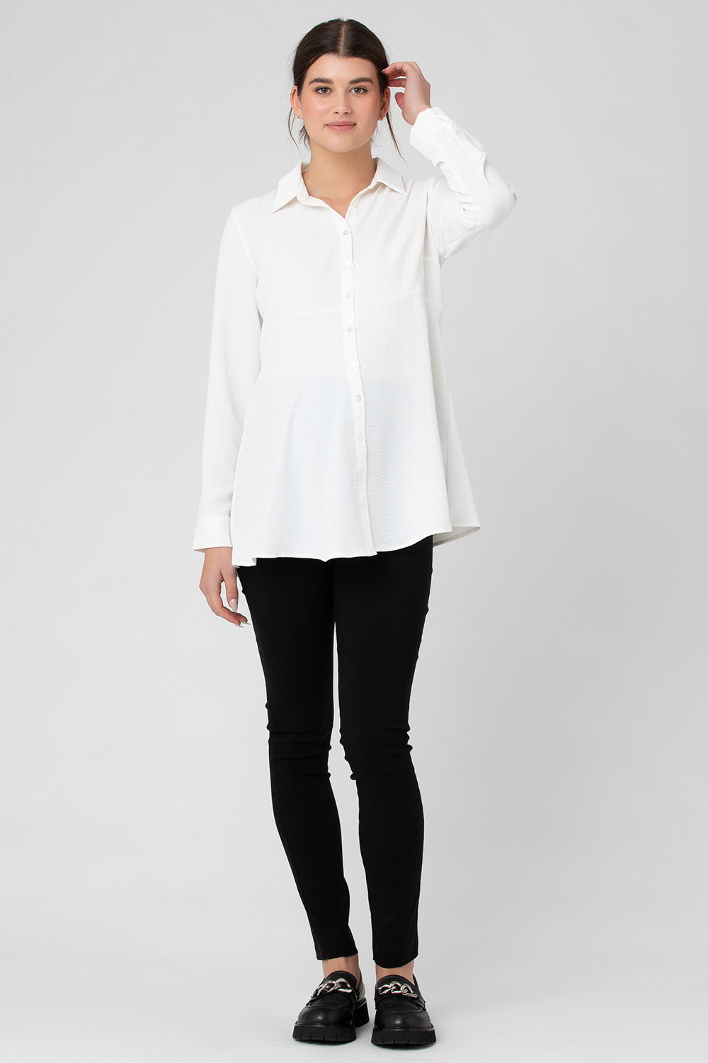 A model wearing the Tina Peplum Shirt in colour White (White), from the front, showing the whole outfit