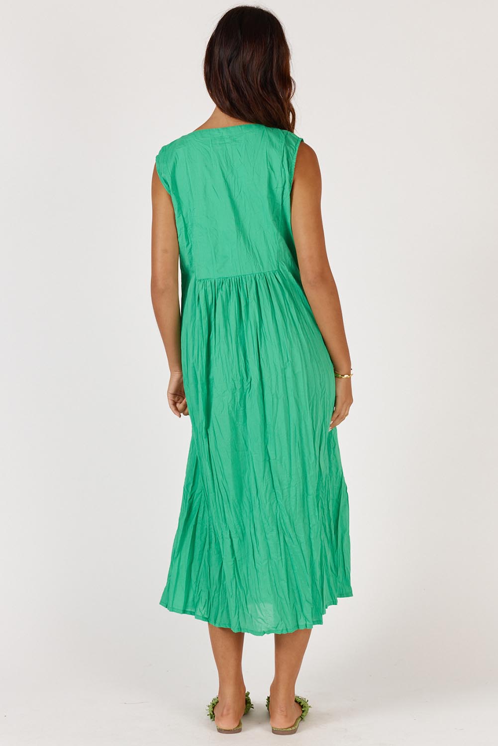 A model wearing the Andaman Cotton Midi Dress in colour Emerald (Green), from the back