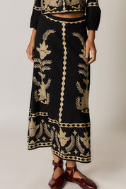 Model Genericm wearing size sample of the Arnun Skirt – Black in colour Black, in a cropped view