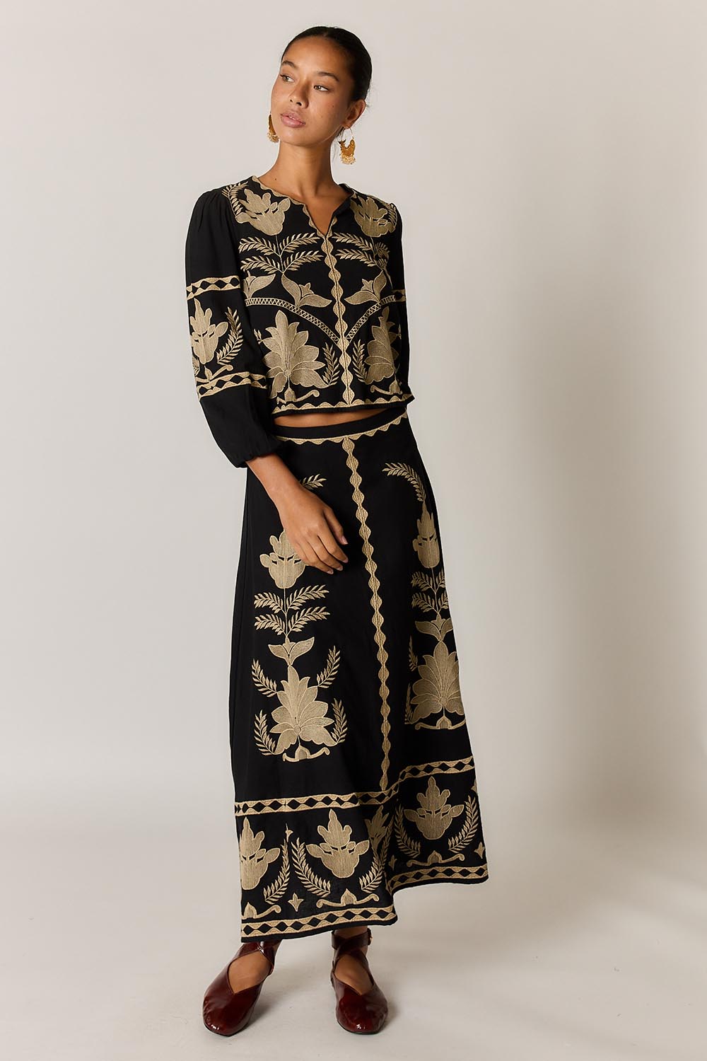 Model Genericm wearing size sample of the Arnun Skirt – Black in colour Black, from the front