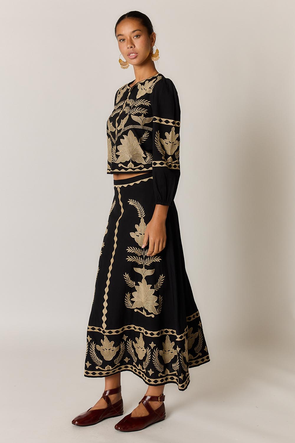 Model Genericm wearing size sample of the Arnun Skirt – Black in colour Black, from the front
