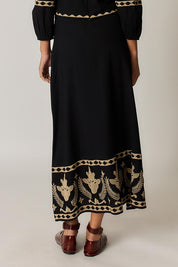Model Genericm wearing size sample of the Arnun Skirt – Black in colour Black, from the front