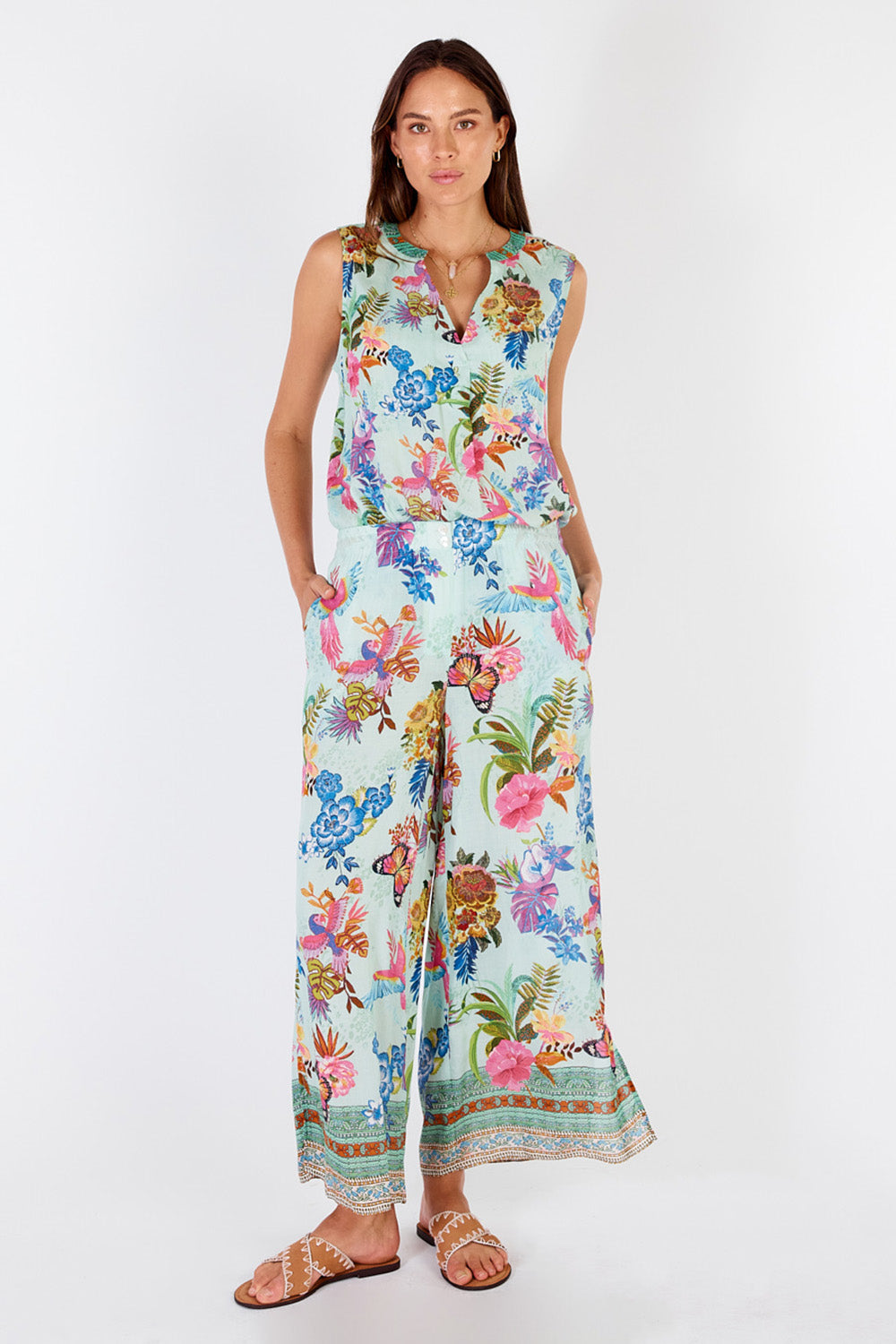 A model wearing the Caatinga Pant in colour Mint (Green), from the front, showing the whole outfit