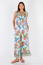 A model wearing the Caatinga Pant in colour Mint (Green), from the front, showing the whole outfit