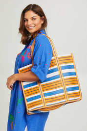 Model Monique wearing size OneSize of the Corfu Bag in colour Orange, from the front, cropped image