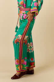 Model Genericm wearing size sample of the Liberte Pant – Green in colour Green, from an angle