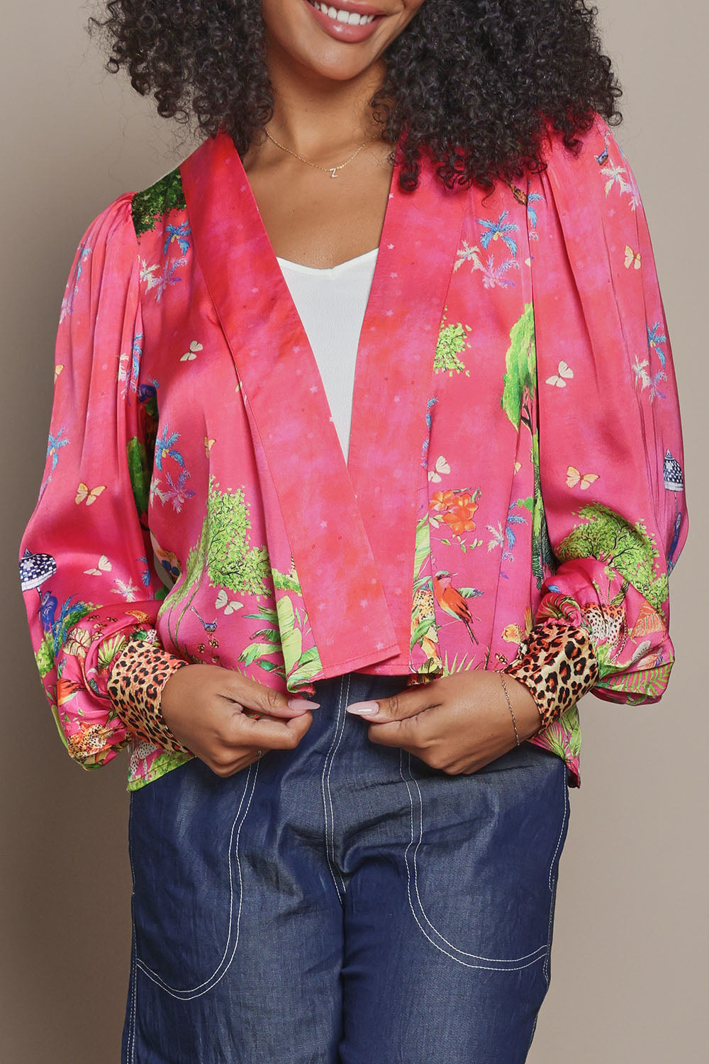 Model Ziara wearing size S of the Mataram Bolero in colour Coral (Pink), from the front, cropped image