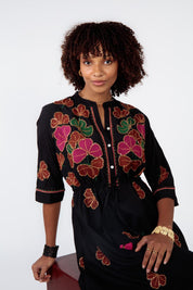A model wearing the Miguel Cotton Dress in colour Black (Black), from the front, cropped image