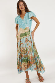 A model wearing the Montpellier Wrap Dress in colour Print (Blue), from the front, showing the whole outfit
