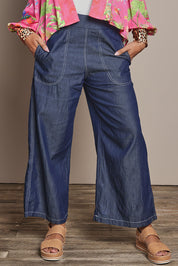 Model Ziara wearing size S of the Pula Pant in colour Denim (Blue), from the front, cropped image