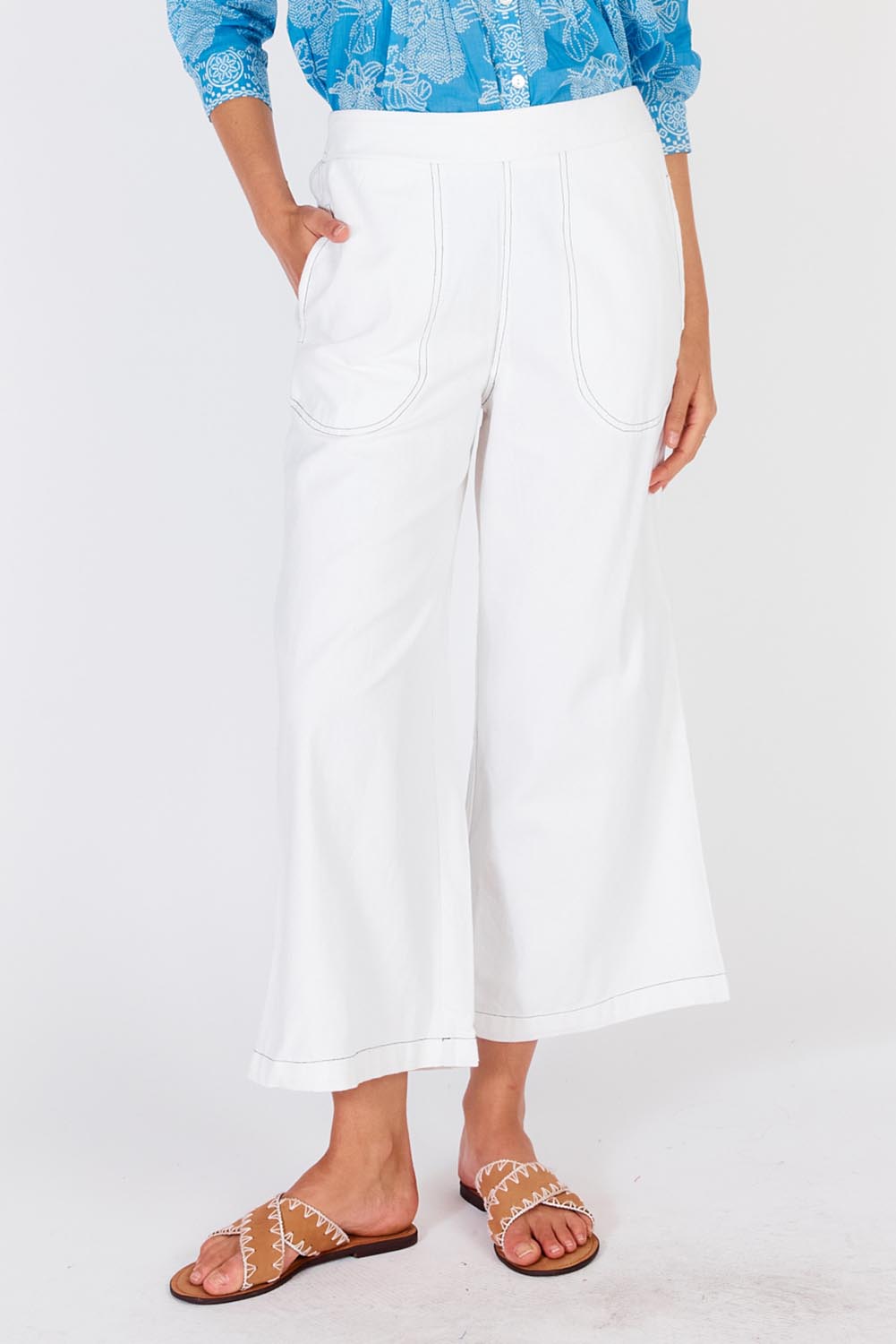 A model wearing the Pula Pant in colour White (White), from the front, cropped image